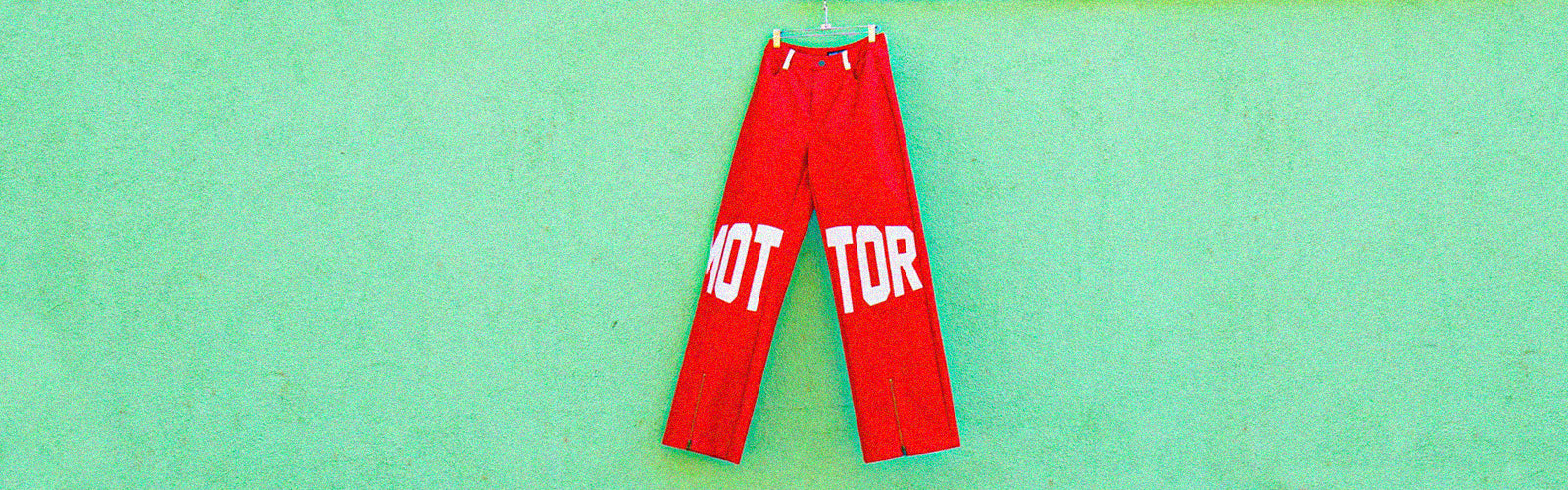 a red pants with white letters on a clothes line
